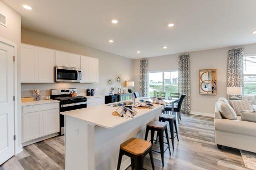 Thoughtfully-designed, modern & fresh describes this kitchen. Equipped with stainless steel appliances, quartz countertops & a large island, this kitchen adds distinction & character to the home. Photo of model home, color & options may vary.