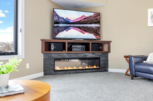 Electric fireplace with stone surround in upper level family room