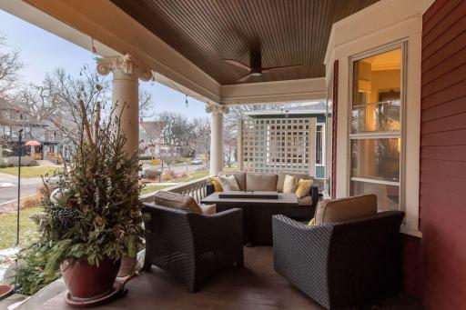 Wide front porch with beadboard ceiling, ceiling fan, and detailed columns.