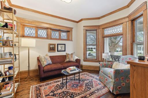 Cozy main level den overlooking the front porch with bay window. Gorgeous natural woodwork and leaded glass set this room apart.