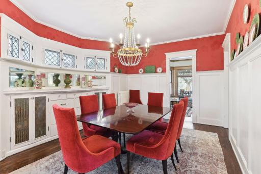 The large dining room easily seats eight people or more. Original features include wainscoting, a plate rail, leaded glass windows, and a built-in service area with storage.