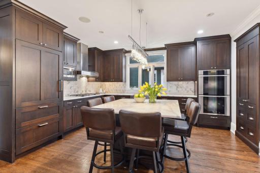 This spacious center island kitchen has been beautifully updated with marble countertops, backsplash, newer cabinetry with excellent storage and updated appliances. Seating for six or more around the kitchen island for informal dining.