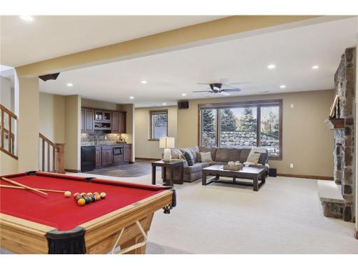 Spacious lower level boasts in-floor heat & offers endless entertaining options! Conveniently walks out to backyard Pool & Hot Tub areas.