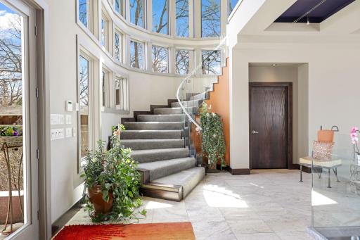 A stunning rounded staircase leads you to the upper level.