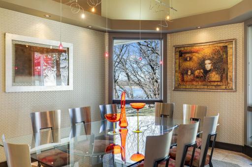Just off the kitchen is a formal dining space with large windows and unique light fixtures.