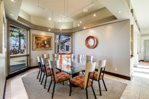 Just off the kitchen is a formal dining space with large windows and unique light fixtures.