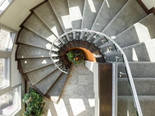 A stunning rounded staircase leads you to the upper level.