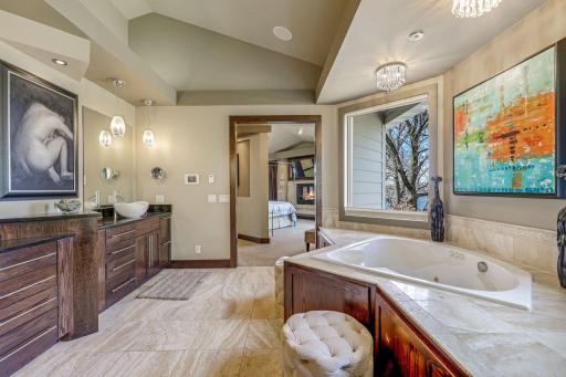 The primary, private bathroom features a large double vanity, 2-person, sun filled shower, two-person jacuzzi tub with a custom ceiling mounted bath filler, heated floors and a private commode room.