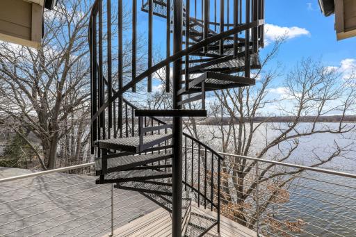 A spiral staircase leads up to the rooftop deck with breathtaking lake and sunset views.