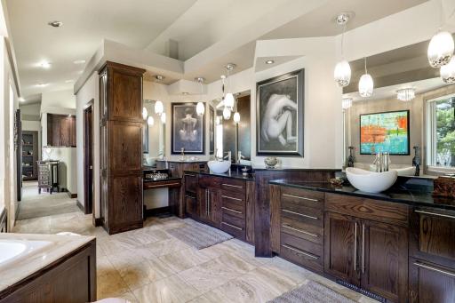 The primary, private bathroom features a large double vanity, 2-person, sun filled shower, two-person jacuzzi tub with a custom ceiling mounted bath filler, heated floors and a private commode room.