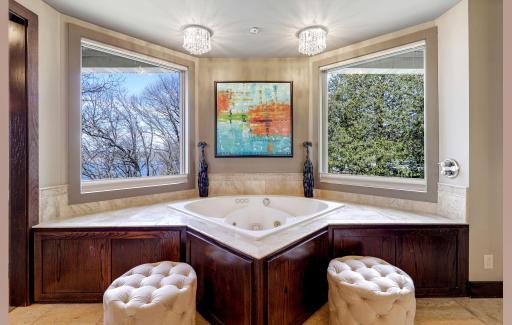 The primary, private bathroom features a large double vanity, 2-person, sun filled shower, two-person jacuzzi tub with a custom ceiling mounted bath filler, heated floors and a private commode room.