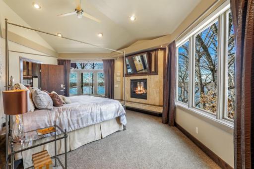 The spacious primary wing features beautiful lake views, a cozy fireplace, a stunning private bathroom, and an enormous closet that walks through to the upper level laundry room.