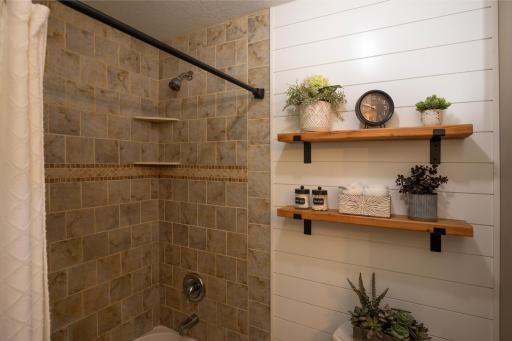 It boasts a tile surround shower/tub and tasteful shiplap