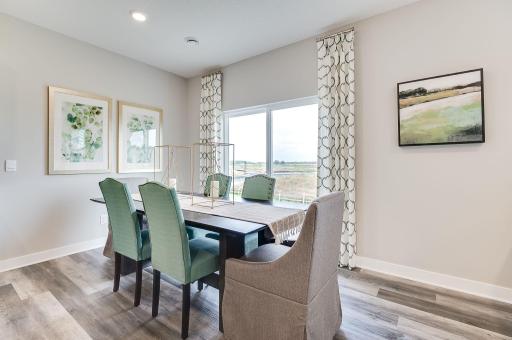 Your dining space is bright and conveniently located near the back patio grill! (Model home, colors will vary)