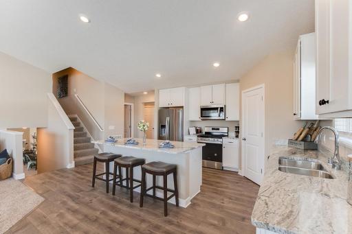 Nice and spacious kitchen island, walk-in pantry, and the sink is placed under the window for some nice daylight. Model home photo, colors and selections may vary.