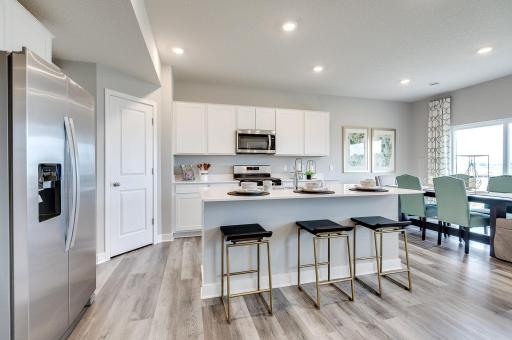 The kitchen is complete with large center island, granite countertops, stainless appliances - including double oven and a luxurious gas cooktop - and walk-in pantry. *Pictures are of a model home, actual colors and finishes may vary.