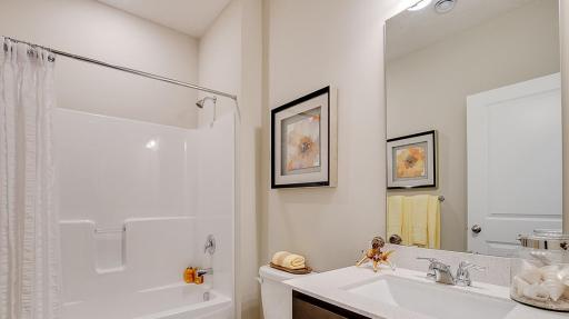 Full bathroom in the front of the home includes tub and shower. Model photo. Options and colors will vary. See listing agent for home specific selections.