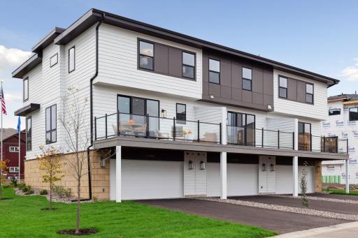 Exterior view of the 3 unit townhome building with large composite deck.
