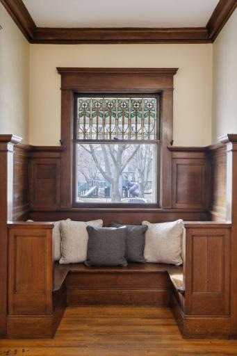 Stained glass inserts are original to the home and stunning! This charming seating area can be used as a reading nook or a morning coffee spot.