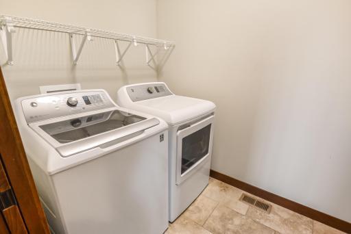 Laundry on the main level includes an adjacent built-in folding bench.