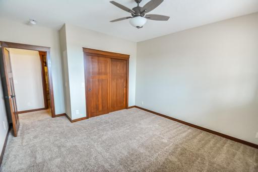 Bedroom #3 on the lower level with lookout windows, ceiling light/fan, and carpet.