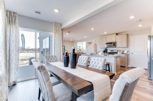 Spacious dining room with ample amounts of natural light adjacent to patio! (Model photo, colors may vary.)