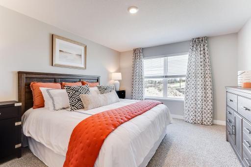 The primary bedroom is bright and open. (Model photo, colors may vary.)