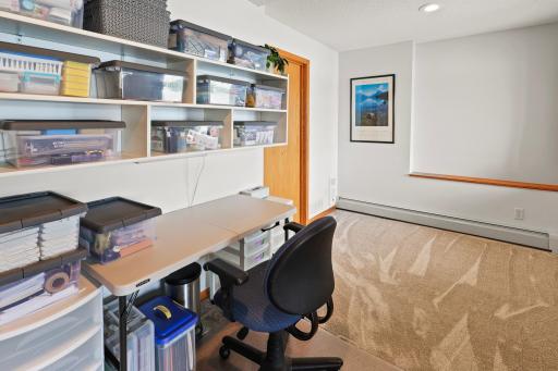 This lower level bedroom is being used as a craft room. There is an enormous storage, utility room right behind it.