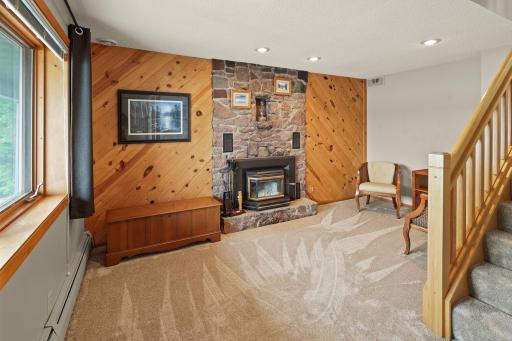 Rustic feeling wood burning fireplace with high efficiency insert & fan.
