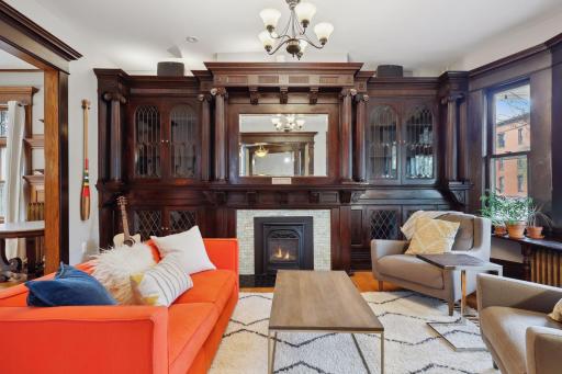 Find a mood-setting gas fireplace flanked by elegant built-in cabinets with leaded glass accents.