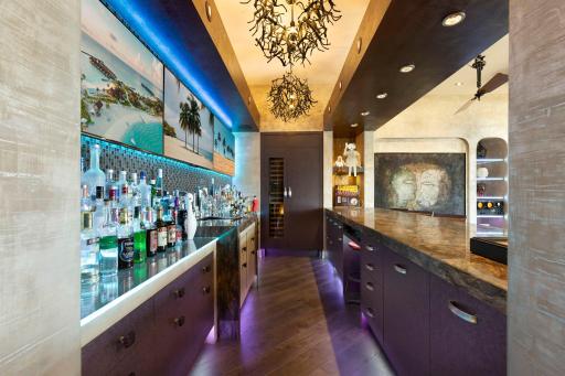 The full sized bar offers abundant storage, a fridge with wine storage, a turn-table set-up, and a martini
shaped bar sink. The floor height behind the bar puts the countertop at counter level, while the seated sided of the bar is at bar top level.
