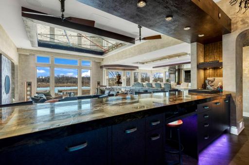 The full sized bar offers abundant storage, a fridge with wine storage, a turn-table set-up, and a martini
shaped bar sink. The floor height behind the bar puts the countertop at counter level, while the seated sided of the bar is at bar top level.