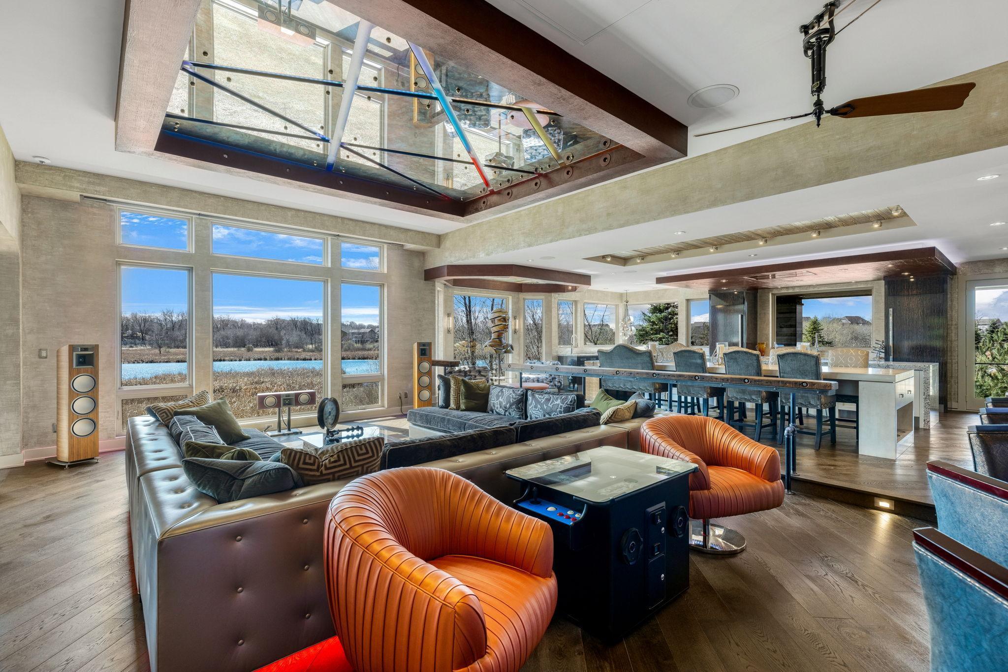 The spacious and open concept living room overlooks the stunning property or the theater style, drop-down projection screen.