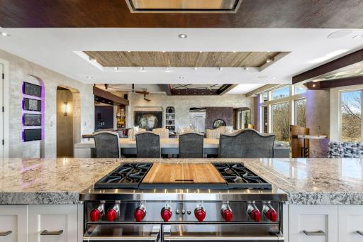 A stunning chefâs kitchen features wall to wall windows, 2 built-in refrigerators, 2 sinks,
a center island range with a ceiling mounted, recessed range hood, double oven, abundant granite
countertop space including a massive center island.