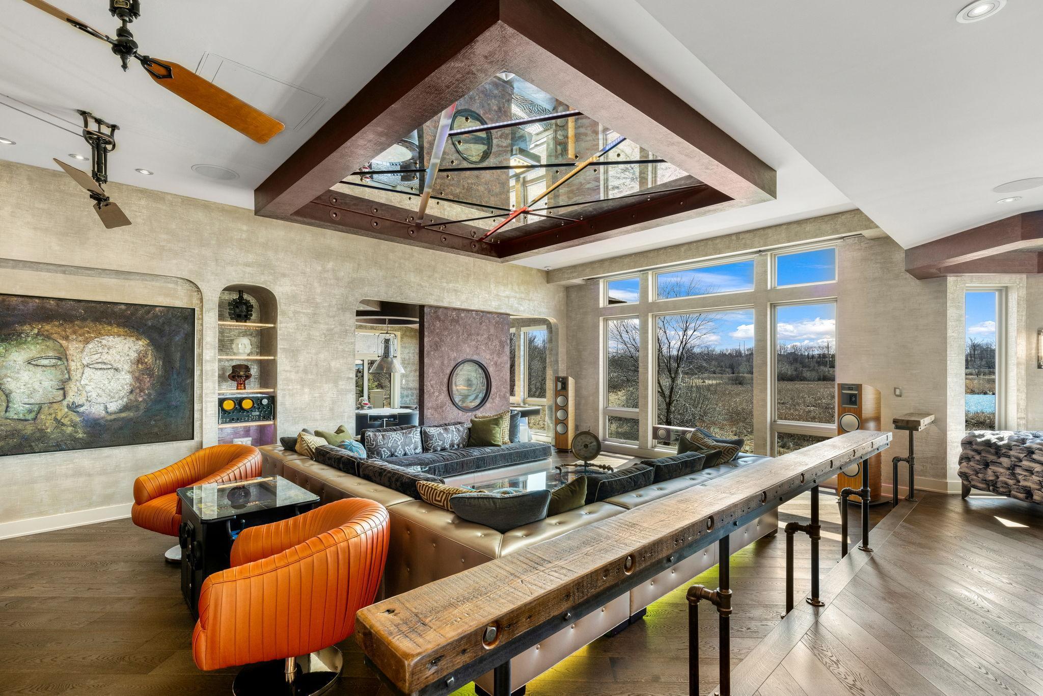 The spacious and open concept living room overlooks the stunning property or the theater style, drop-down projection screen.