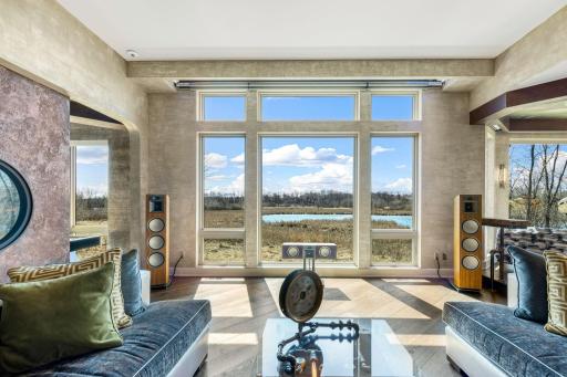 The spacious and open concept living room overlooks the stunning property or the theater style, drop-down projection screen.