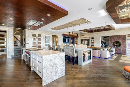 A stunning chefâs kitchen features wall to wall windows, 2 built-in refrigerators, 2 sinks,
a center island range with a ceiling mounted, recessed range hood, double oven, abundant granite
countertop space including a massive center island.