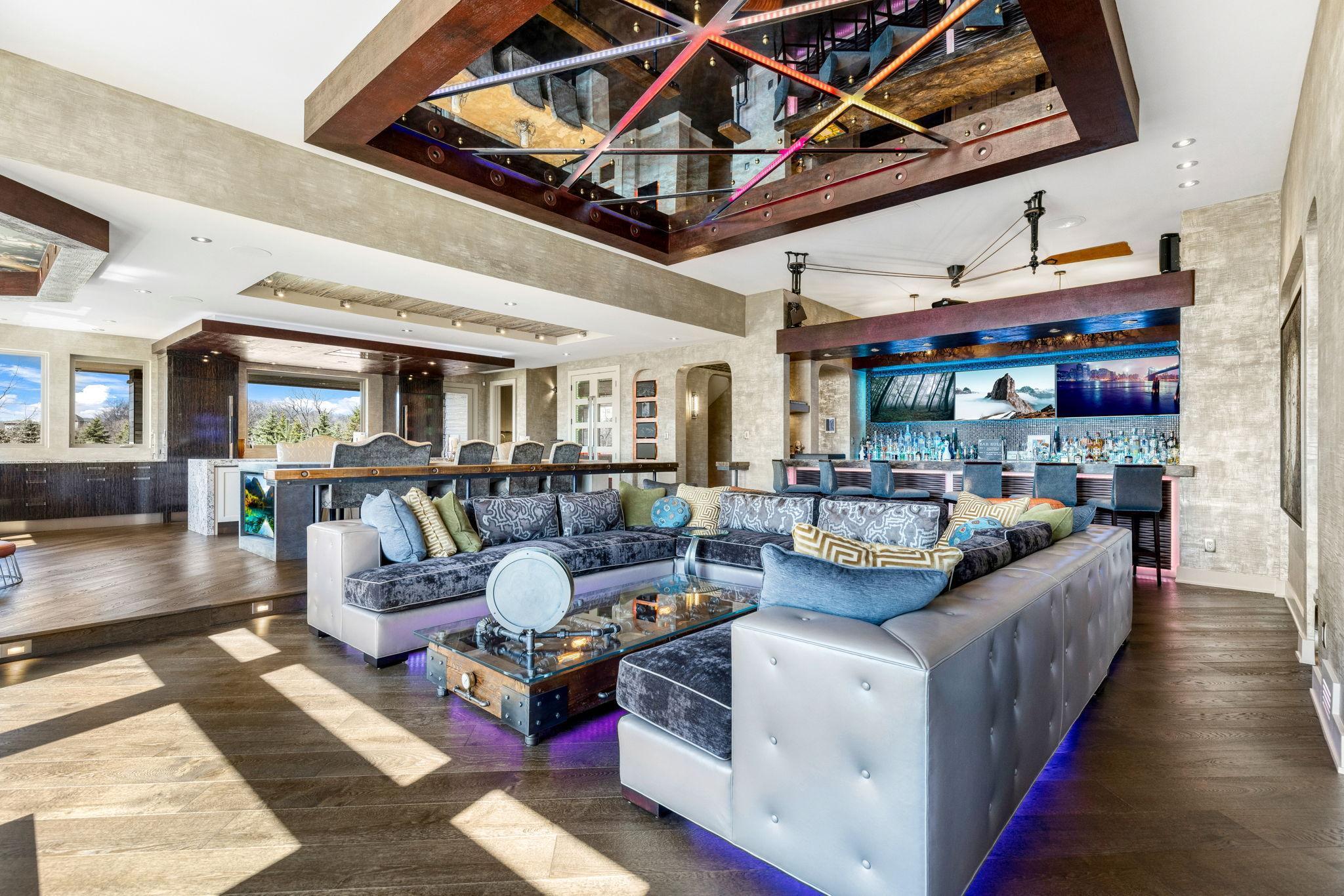 The spacious and open concept living room overlooks the stunning property or the theater style, drop-down projection screen.