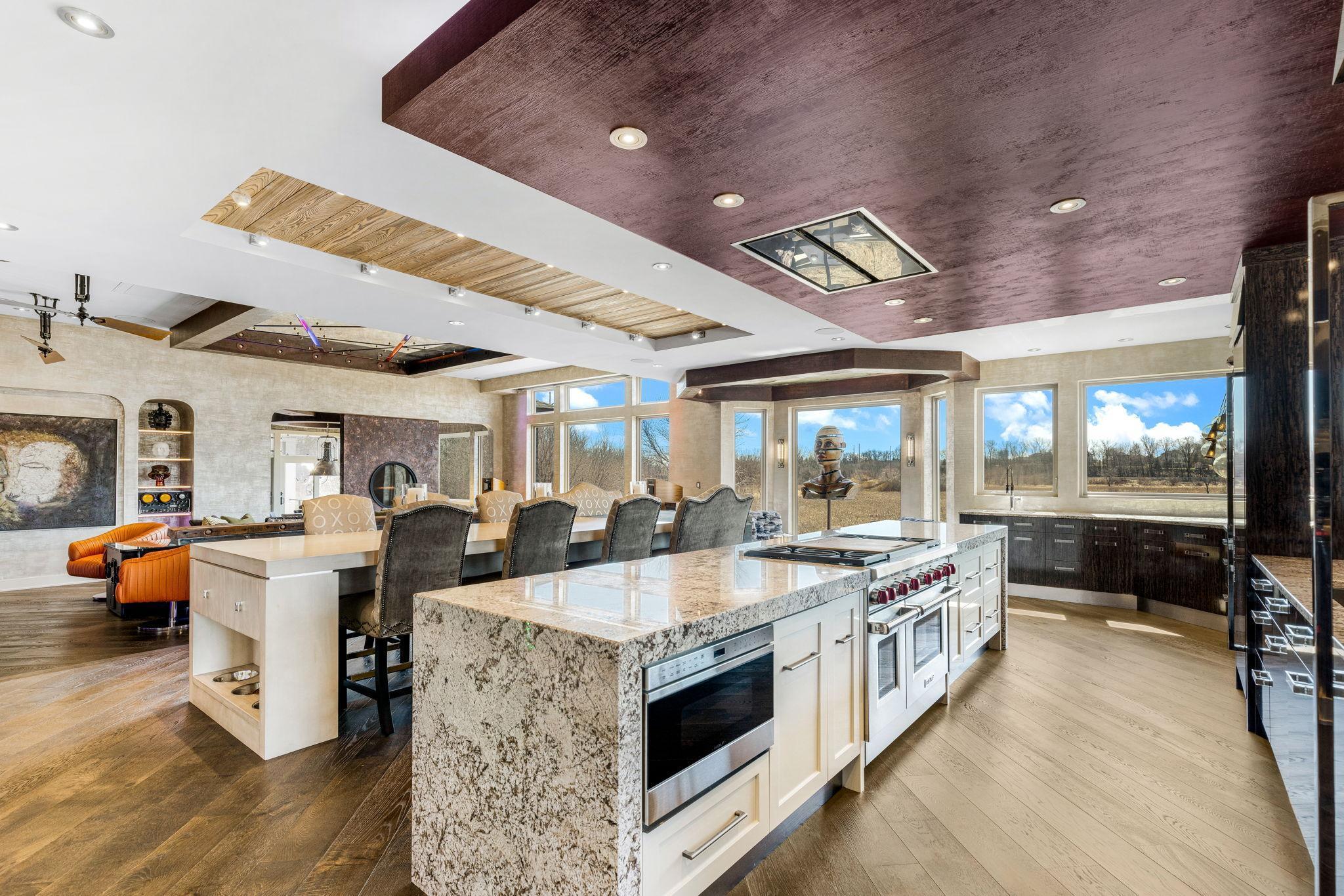 A stunning chef’s kitchen features wall to wall windows, 2 built-in refrigerators, 2 sinks,
a center island range with a ceiling mounted, recessed range hood, double oven, abundant granite
countertop space including a massive center island.