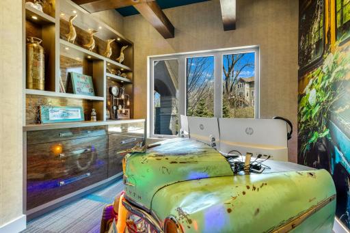 The inspiring main level office has custom, lighted, built-in cabinetry, exposed beams and a one-of-a-kind,
vintage car desk with a horn that sounds along with the doorbell.
