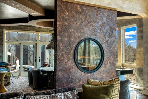 A unique 2-sided circular, gas fireplace joins the game room and living room space.