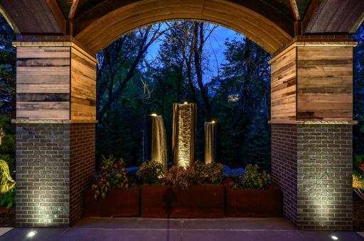 A stunning water fountain feature greets you at the covered, grand entrance of this home.