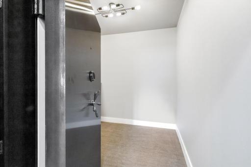 The generous safe room with poured concrete walls, a vault door and Control4 access.