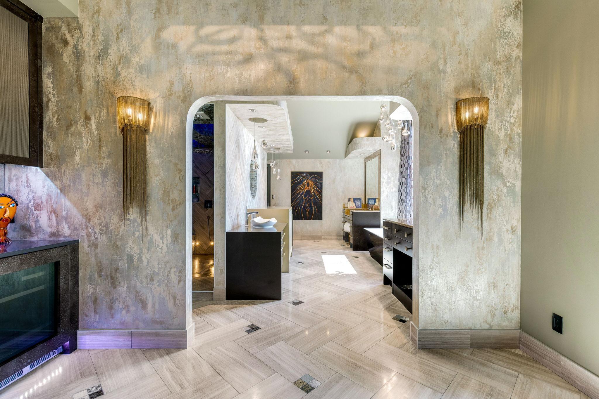 The bright and open primary bathroom offers a massive 2-person shower, 2 separate, commode rooms with custom toilets, extensive Corian countertop vanity space and a large soaking tub with private views