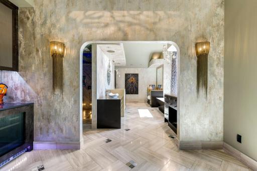 The bright and open primary bathroom offers a massive 2-person shower, 2 separate, commode rooms with custom toilets, extensive Corian countertop vanity space and a large soaking tub with private views