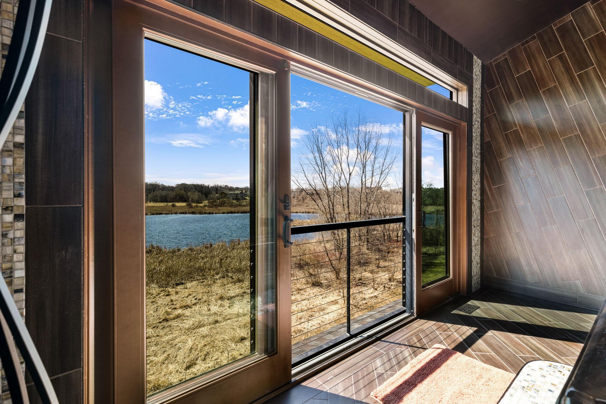 An incredible indoor/outdoor hot tub room features floor to ceiling tile featuring custom sparkly grout
and a stunning artistic light fixture.