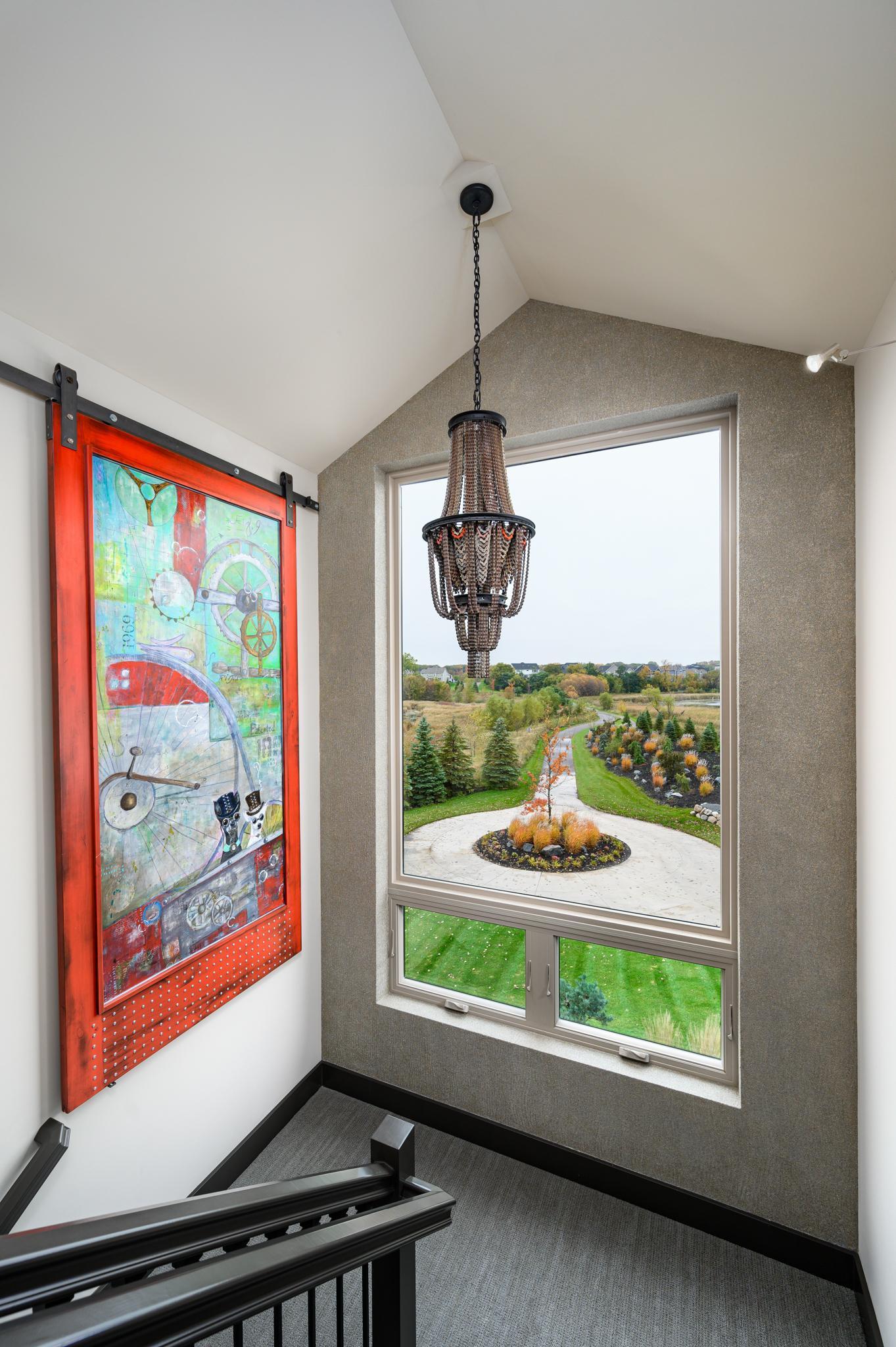 The second of three 2nd floor bedrooms has a unique sliding window opening to the grand stairway.
