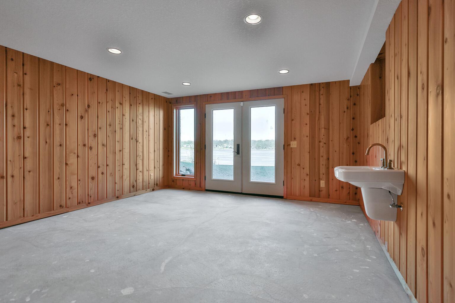 Basement level of more recent addition also walks out to lake. Planned for a "Beach Room" for summer parties.