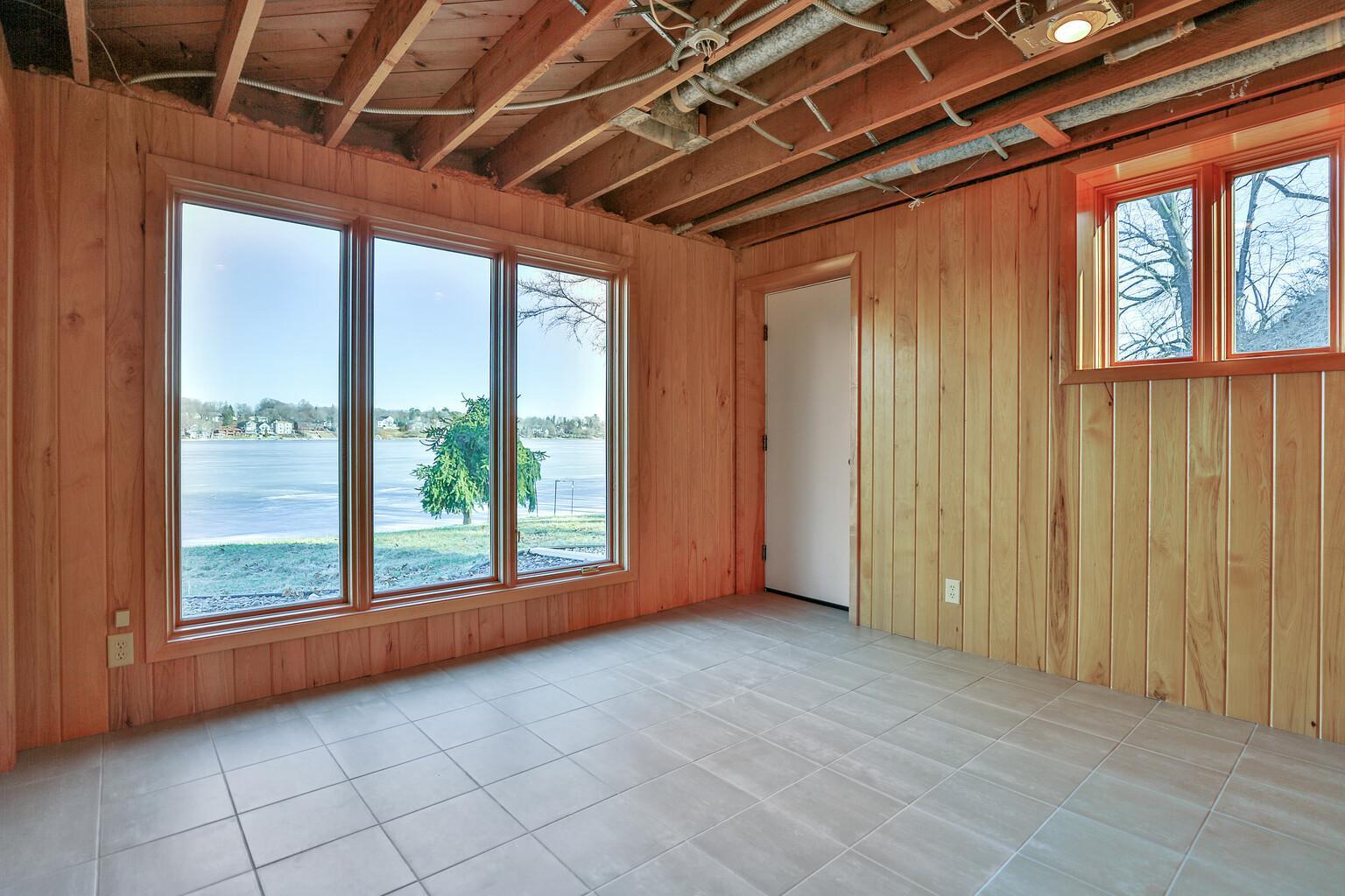 Corner basement bedroom at lakeside with exterior door.