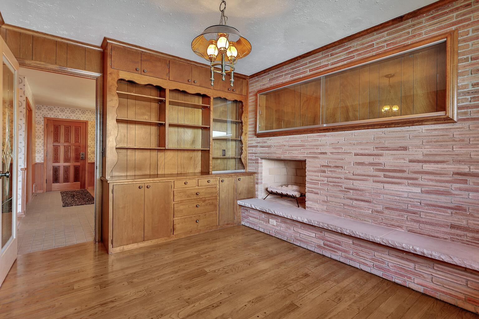 Full wall of built in shelves, wood burning fireplace likely a good location for an insert and gas log.